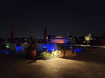 Lakeside pool at night, with lights in the pool